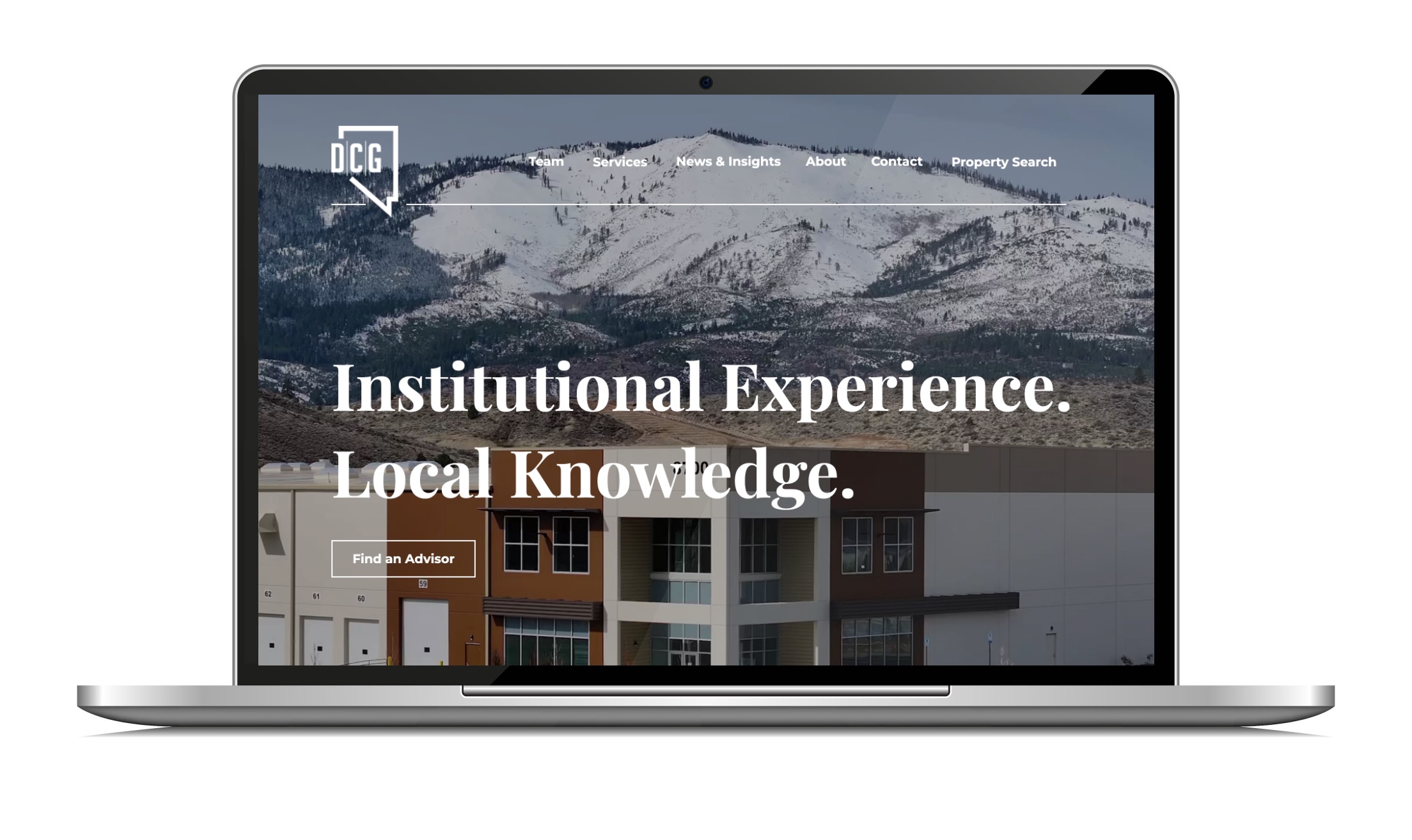 Laptop showing a commercial real estate homepage, with a large serif headline over footage of snow-covered foothills